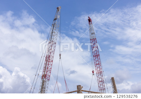 Crawler crane on blue sky white clouds background, Real estate industry. Red crawler crane use reel lift up equipment in construction site. Crane for rent. Crane dealership for construction business. Crawler crane on blue sky white clouds background, Real estate industry. Red crawler crane use reel lift up equipment in construction site. Crane for rent. Crane dealership for construction business. 129538276