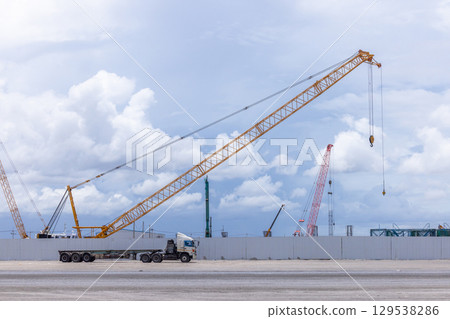 Construction site with construction crawler cranes and multi storey unfinished buildings, Many high rise cranes and industrial construction equipment, Contruction site blue sky background. 129538286