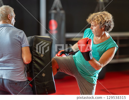 Two men practicing punching during self-defense training 129538315