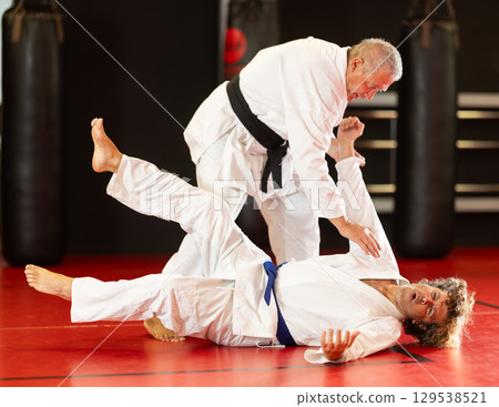 Karate with male athletes practicing, training and sparring in fight class Karate with male athletes practicing, training and sparring in fight class 129538521