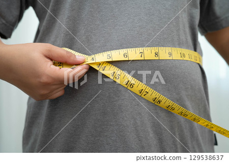 Asian woman with fat belly big size overweight and obesity with measure tape. 129538637
