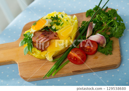 Baked potato stuffed with herbs, egg, bacon Baked potato stuffed with herbs, egg, bacon 129538680