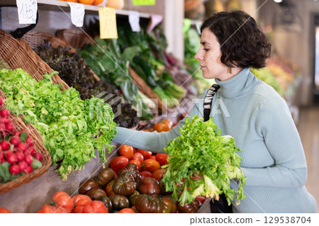 Portrait of woman buying arugula in grocery shop 129538704