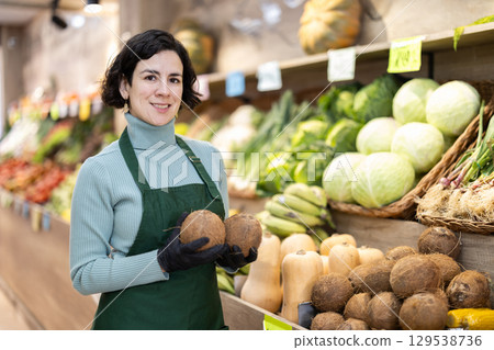 Woman shop seller puts cocoanut goods on display case Woman shop seller puts cocoanut goods on display case 129538736