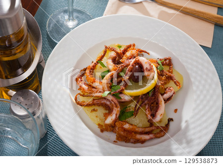 Roasted squid legs with lemon 129538873