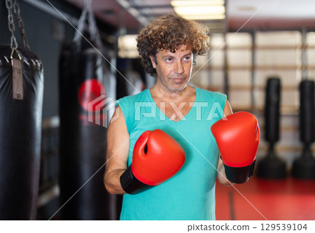 Man in red boxing gloves standing in gym 129539104
