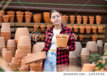 Portrait of woman choosing pots for flowers in gardening market 129539168