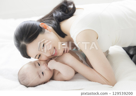 年輕的母親照顧她的孩子 年輕的母親照顧她的孩子 129539200