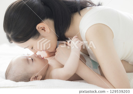 年輕的母親照顧她的孩子 年輕的母親照顧她的孩子 129539203