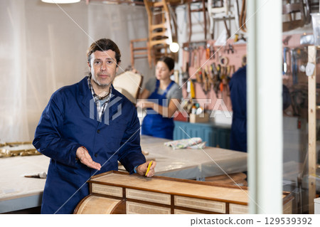 Male furniture workshop worker designing vintage chest of drawers 129539392