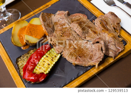 Beef steak with baked potatoes, romesco, vegetables Beef steak with baked potatoes, romesco, vegetables 129539513