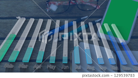 Image of graph processing data over notebook, pens and smartphone on desk 129539783