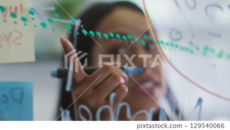 Image of graphs over woman talking in office Image of graphs over woman talking in office 129540066