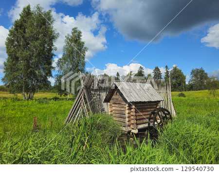 watermill on a stream among thick green grass watermill on a stream among thick green grass 129540730