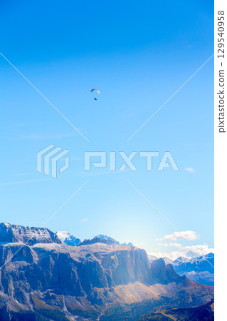 Flying paraglider, Mountain of Dolomites, Italy Flying paraglider, Mountain of Dolomites, Italy 129540958
