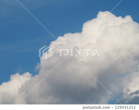 潔白的雲朵漂浮在藍色的夏日的天空 潔白的雲朵漂浮在藍色的夏日的天空 129541252