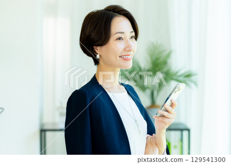 Business woman operating a smartphone in the office 129541300