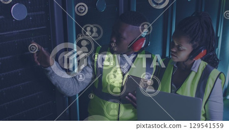 Image of falling icons over african american couple server room workers using headphones 129541559