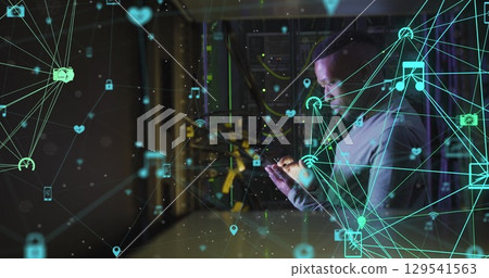 Image of network of connections with icons over african american male server room using tablet Image of network of connections with icons over african american male server room using tablet 129541563