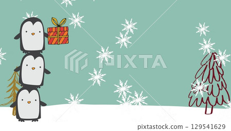 Balancing three penguins on snowy field with flakes, gift box, pine sprig, red tree, copy space 129541629