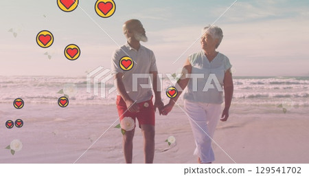 Image of falling hearts over african american senior couple on the beach 129541702
