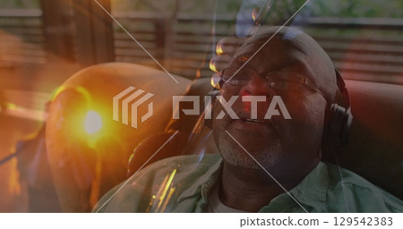 Image of caucasian man playng guitar over african american man wearing headphones Image of caucasian man playng guitar over african american man wearing headphones 129542383