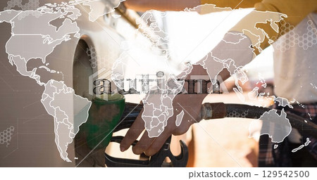 Gripping hands holding green fuel pump nozzle at petrol station forecourt, with world map overlay Gripping hands holding green fuel pump nozzle at petrol station forecourt, with world map overlay 129542500