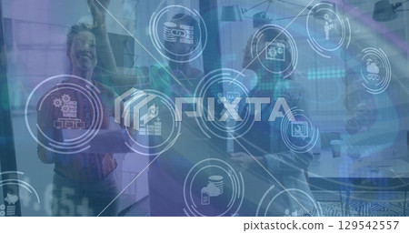 Image of financial data and icons over diverse coworkers in office 129542557