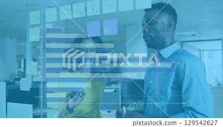 Image of graphs over diverse female and male coworkers in office 129542627