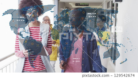 Image of world map over diverse business people in office Image of world map over diverse business people in office 129542674
