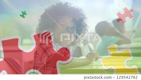 Image of puzzle pieces over diverse teacher and schoolchildren Image of puzzle pieces over diverse teacher and schoolchildren 129542762