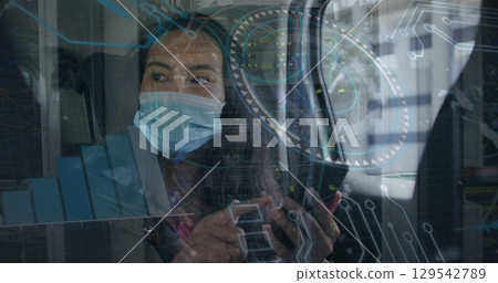 Image of data processing over woman with face mask using smartphone 129542789