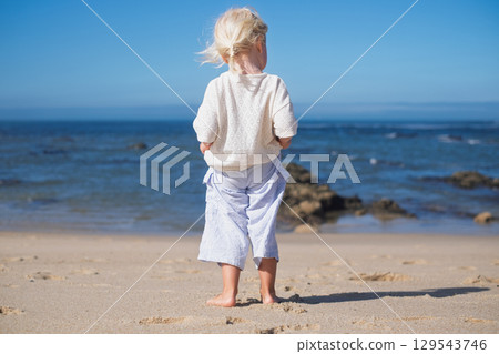 Little blonde European girl walking on an empty sandy beach in Portugal Little blonde European girl walking on an empty sandy beach in Portugal 129543746