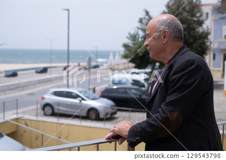 Elderly Spanish Man Walking in a Portuguese City and Looking at the Ocean. He Wears a Jacket and Has a Mustache Elderly Spanish Man Walking in a Portuguese City and Looking at the Ocean. He Wears a Jacket and Has a Mustache 129543798