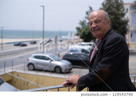 Elderly Spanish Man Walking in a Portuguese City and Looking at the Ocean. He Wears a Jacket and Has a Mustache Elderly Spanish Man Walking in a Portuguese City and Looking at the Ocean. He Wears a Jacket and Has a Mustache 129543799