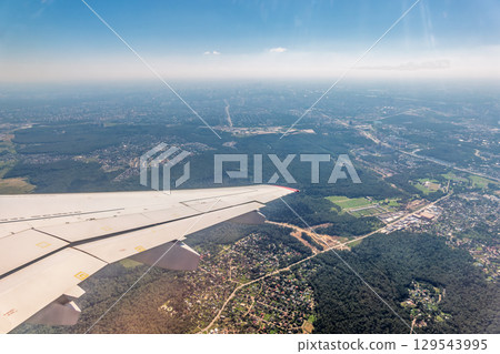 View from the airplane window during taking off on a clear summer morning View from the airplane window during taking off on a clear summer morning 129543995