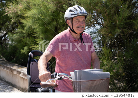 Elderly Man with Mustache and Helmet Riding a Bicycle 129544012
