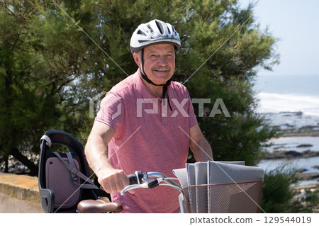 Elderly Man with Mustache and Helmet Riding a Bicycle Elderly Man with Mustache and Helmet Riding a Bicycle 129544019
