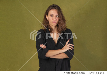 Pensive woman with crossed arms 129544341