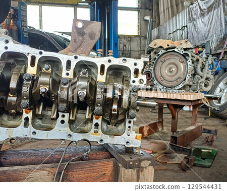 A disassembled car engine in a repair shop. A disassembled car engine in a repair shop. 129544431