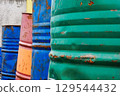 Old large multi-colored barrels from under machine oil or fuel. 129544432