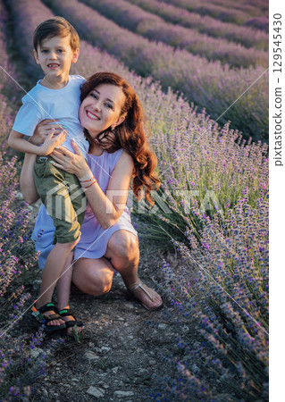 Mom and son walking in a lavender field 129545430