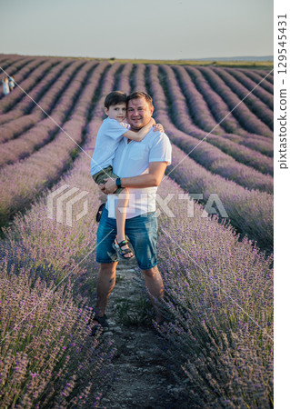 Man with son on a lavender field Man with son on a lavender field 129545431