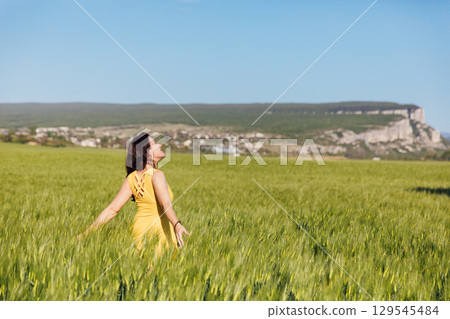 woman in a yellow dress in a field of wheat woman in a yellow dress in a field of wheat 129545484