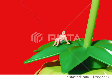 a miniature man rests on a green leaf 129545567