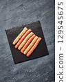 Raw butchers sausages on slate. Overhead view 129545675
