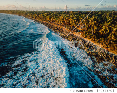 Coastline at sunrise or sunset with waves at tropical island, drone view 129545801