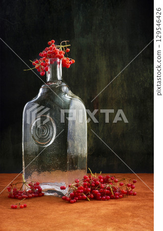 Still-life with viburnum red and empty glass bottle 129546426