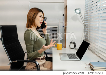 women talk mobile phones update tasks with milestones progress planning while working on laptop computers, online business, teleworking concept. 129546541