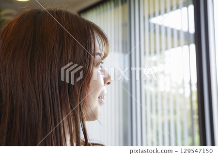 一位女士凝視著窗外的側影 129547150